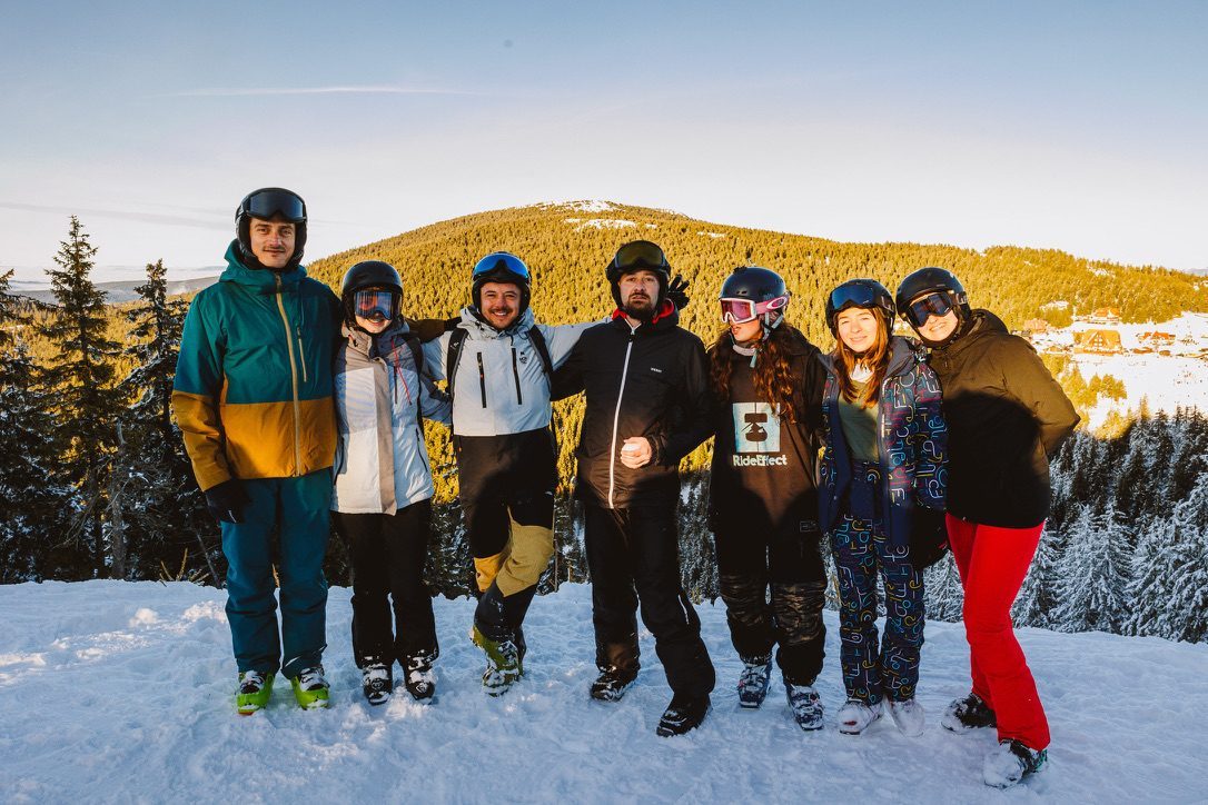 Group of skiers celebrating on a Romanian slope at golden hour