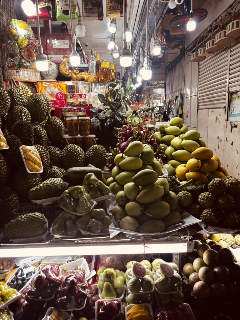 Night market in Vietnam — tropical fruit stalls piled high under warm lights